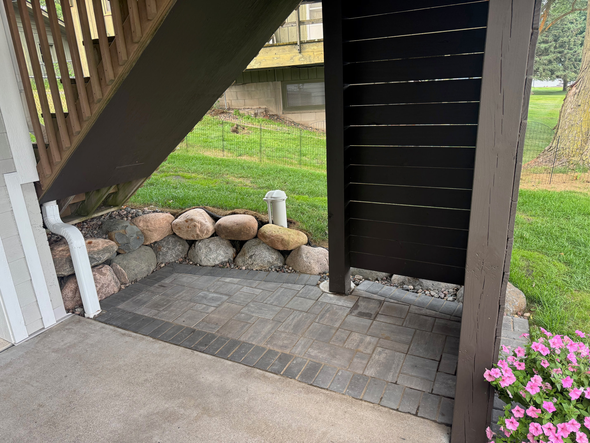Small paver patio installed beneath a deck.