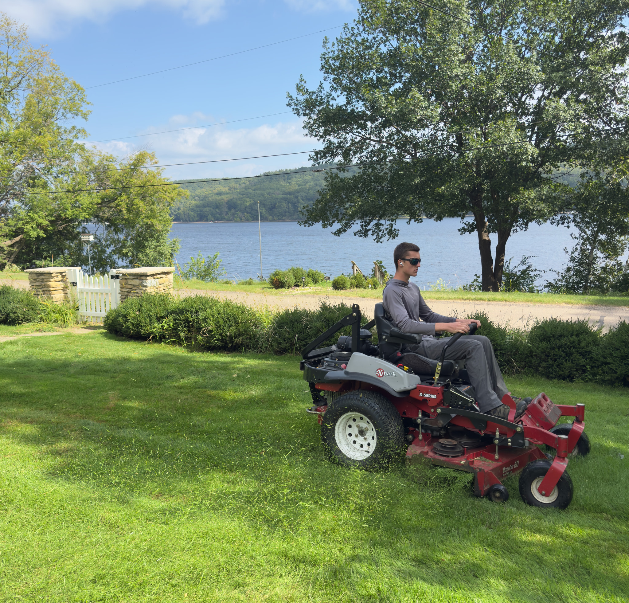 Weekly lawn mowing on a lakefront property using a commercial mower.